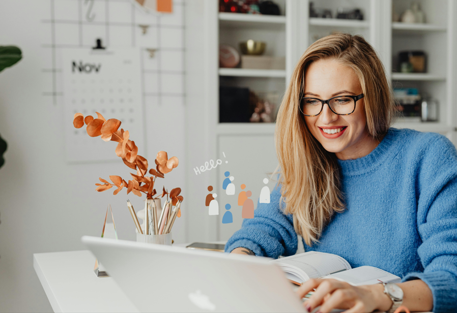 Jeune femme souriante travaillant sur son ordinateur portable, symbolisant l’apprentissage et la préparation au rôle de manager.