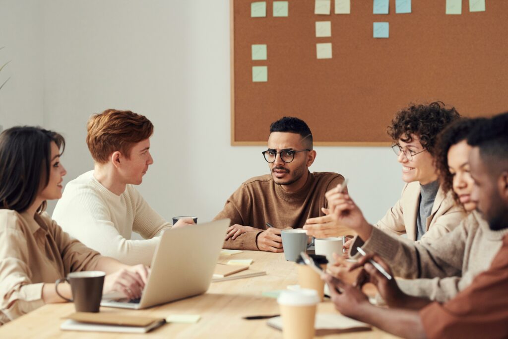 Groupe de collègues en réunion, illustrant l’apprentissage entre pairs en entreprise